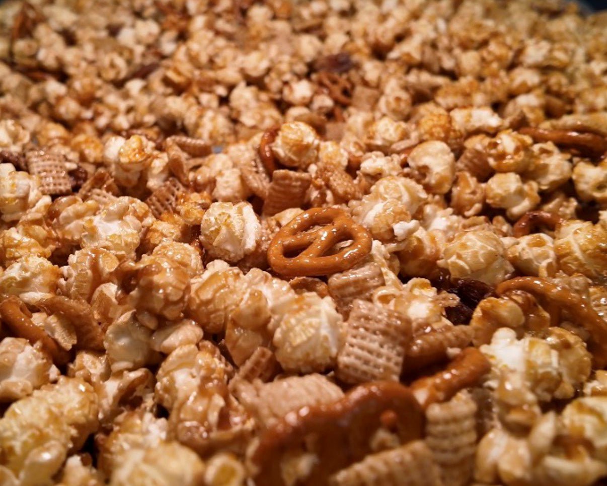 Golden caramel popcorn, pretzels and pecans on a tray